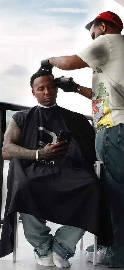 Mobile barber cutting Moneybagg Yo's hair on a Miami balcony